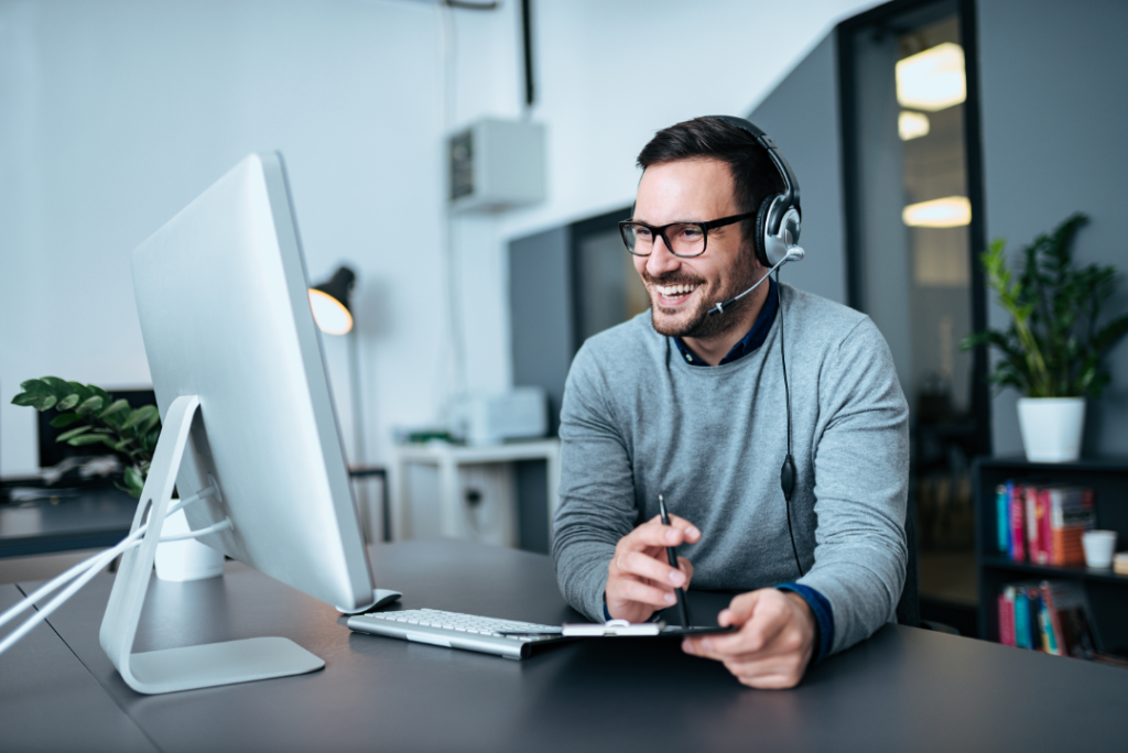 smiling businessman using headset when talking to customer.