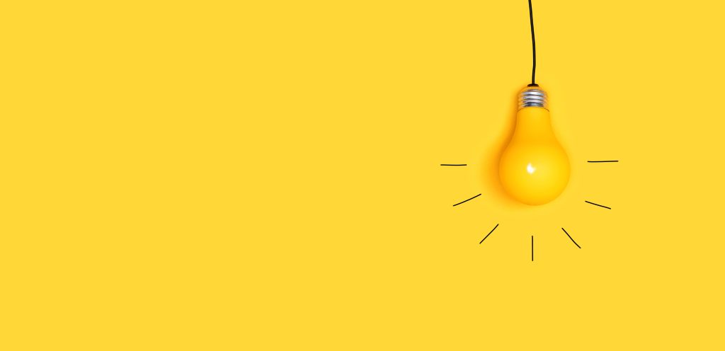 One hanging light bulb on a yellow background